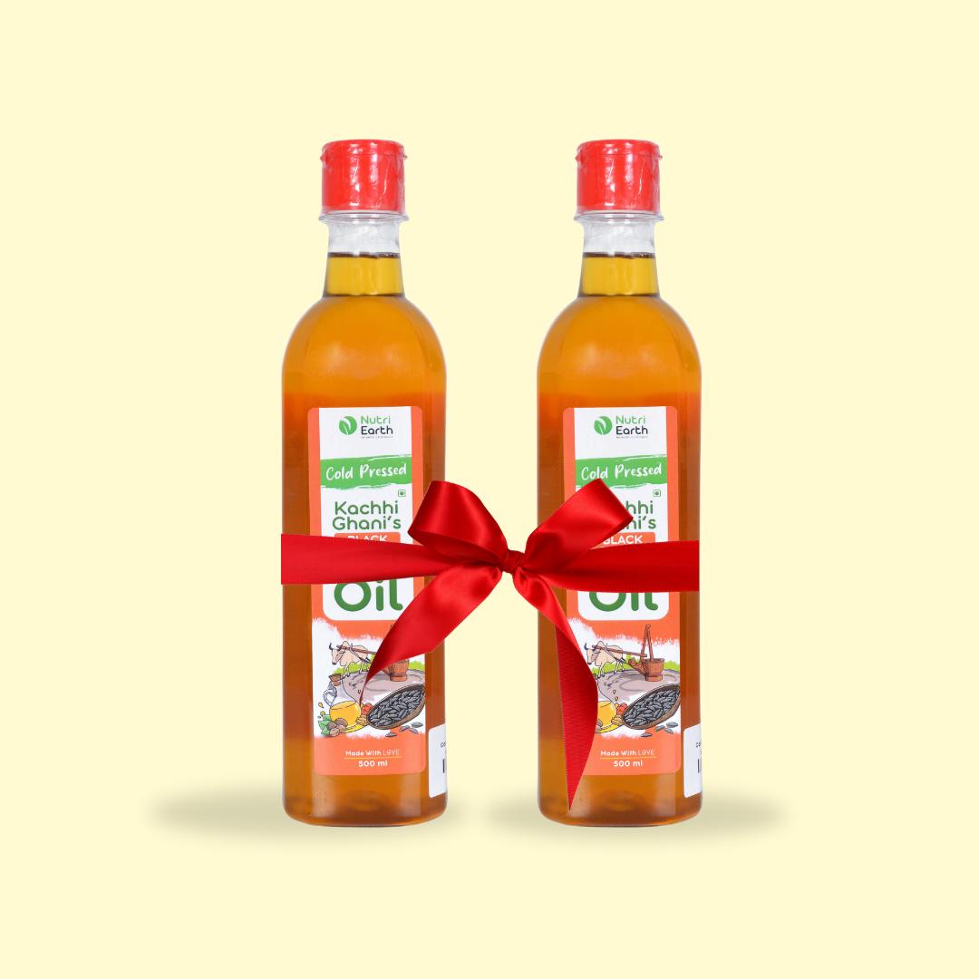 Nutriearth Wooden Cold Pressed Black Sesame Oil in bottle with black lid, bundled with a red ribbon. Premium wood cold pressed oil buy online.