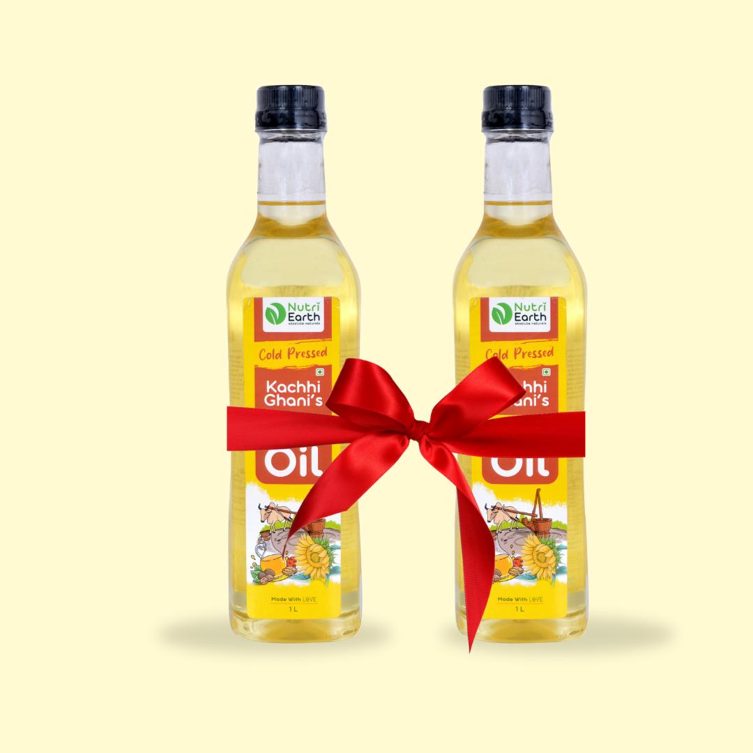 Nutriearth Wooden Cold Pressed Sunflower Oil in bottle with black lid, bundled with a red ribbon. Premium wood cold pressed oil buy online.
