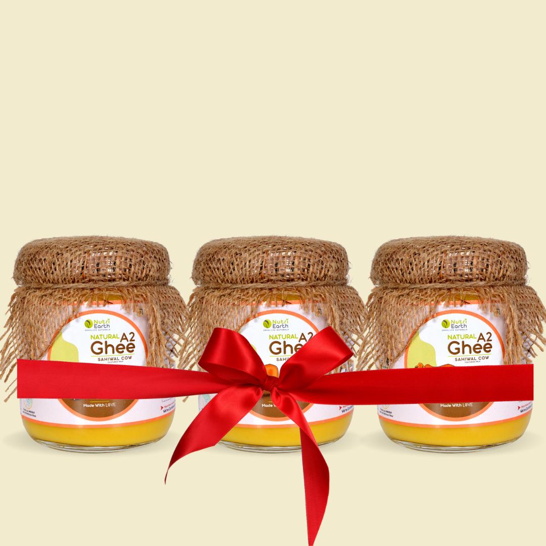 Nutriearth A2 Cow Ghee Sahiwal in glass jars with jute covers and red ribbon, showcasing premium hand-biloana desi ghee for healthy cooking.