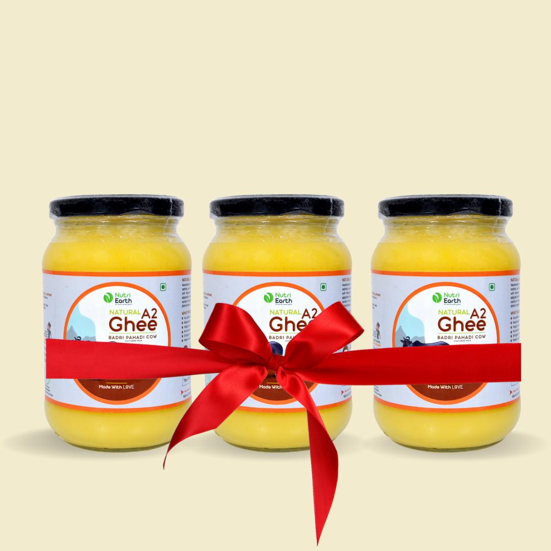 Nutriearth A2 Cow Ghee Badri in glass jars with jute covers, bundled with a red ribbon. Premium dairy product from (Himalayan Cow) cow milk.